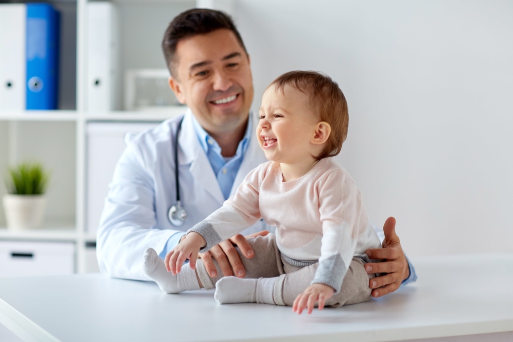 Smiling baby with male doctor